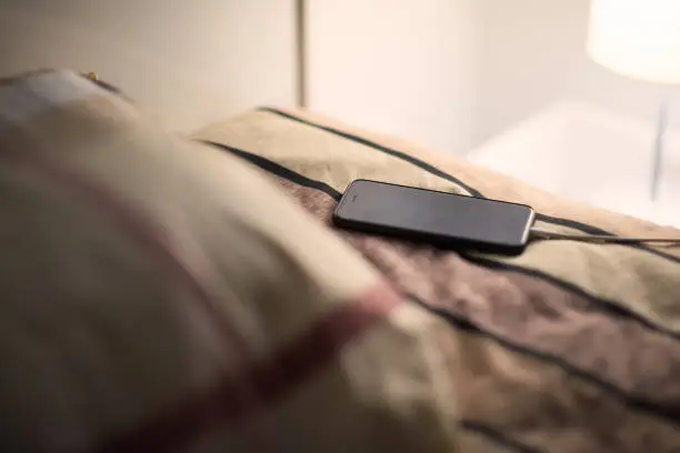 Photo of Smartphone is charging on bed