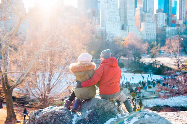 Happy family enjoy the view of famous ice-rink in Central Park in New York City
