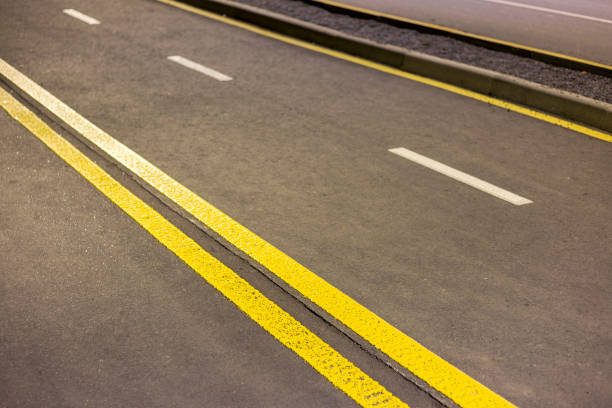 istock Wide bright double yellow marking sign line along modern wide smooth empty asphalt highway street stretching to horizon. Speed, safety, comfortable journey and professional road building concept. 1087479406