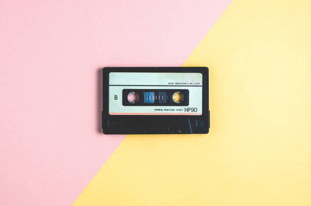 istock Old audio cassette tape on pink-yellow  background 1087486992