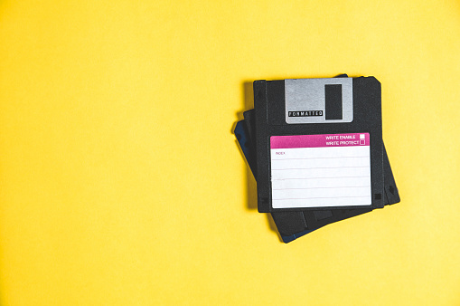 Viejos disquetes de ordenador sobre fondo amarillo photo
