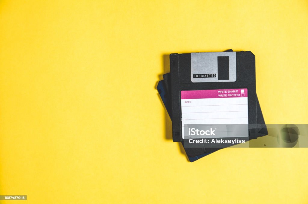 Old floppy disks for computer on yellow background Floppy Disk Stock Photo