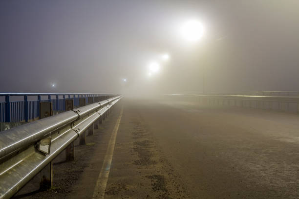 istock Thick fog over empty road at night 1087494066