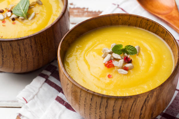 istock Pumpkin soup mashed with spices in wooden bowls on light boards. 1087494450