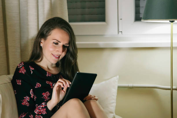 istock Woman relaxing at home with a digital tablet 1087496342