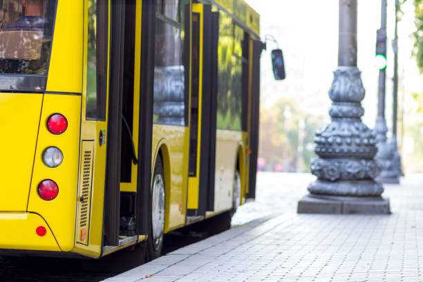 Modern yellow city bus with open doors at bus station