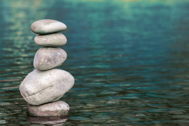 istock Stack of stones balancing on top in blue water of the river 1087501058