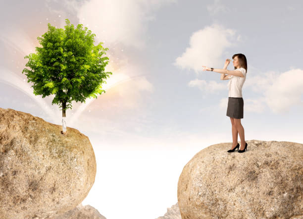 istock Businesswoman on rock mountain with a tree 1087503126