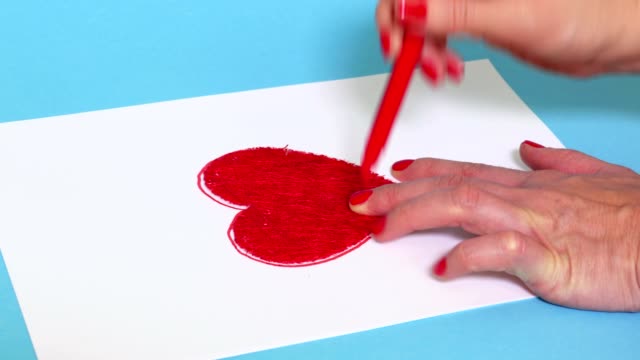 Woman drawing red heart shape