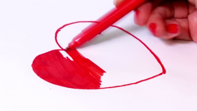 Woman coloring red heart shape