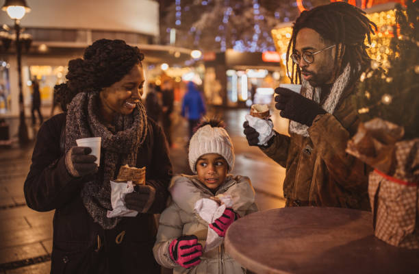 Warm drink is always welcome Young family preparing for Christmas holiday. They have short break at street cafe. girls getting ready to go out stock pictures, royalty-free photos & images