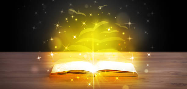 istock Open book with golden glow flying paper pages 1087508506