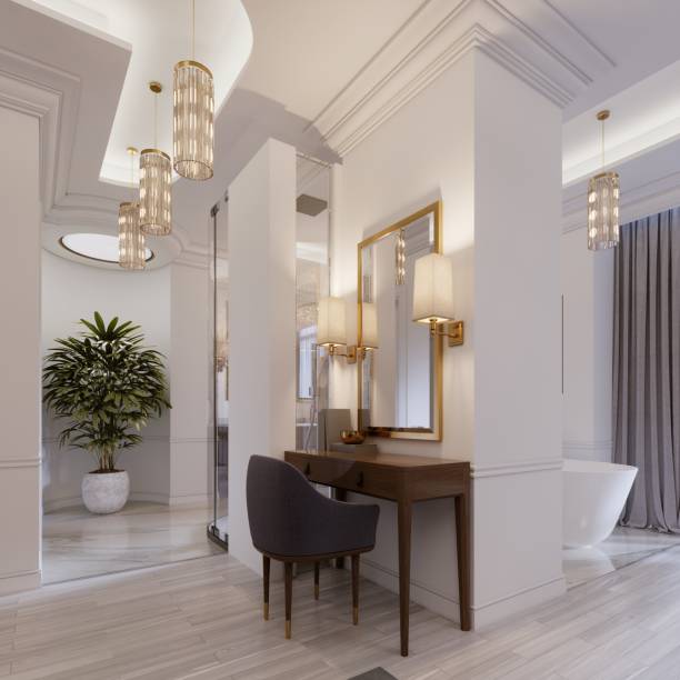 istock Designer working and dressing table made of wood with a mirror in a gilded frame and glowing sconces on the wall in the suite. 1087511144
