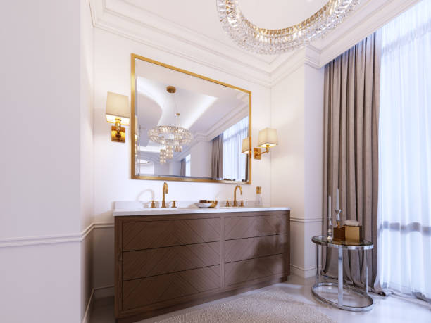 istock Modern wooden vanity with a mirror in a gold frame and sconces on the wall, a low table with decor and a rug with a chandelier. 1087513740