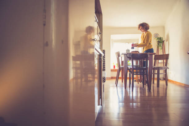 istock Young woman having breakfast in her kitchen 1087518406