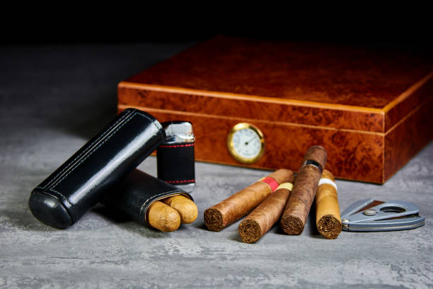 istock Six Cuban cigars on a stone table with a lighter, cutter and a wooden humidor. Leather case. 1087519778