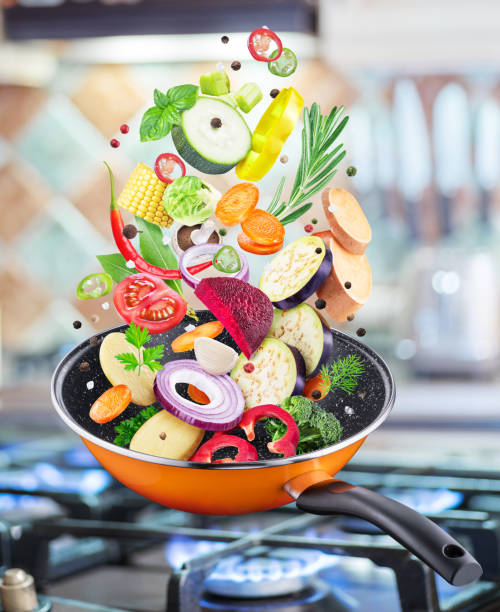 istock Flying fresh vegetables and spices falling into a pan. 1087520466
