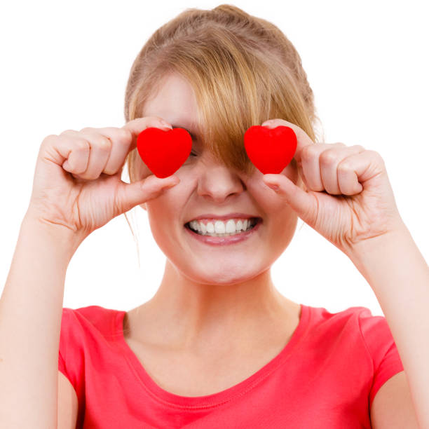 istock Funny woman holds red hearts over eyes 1087524272