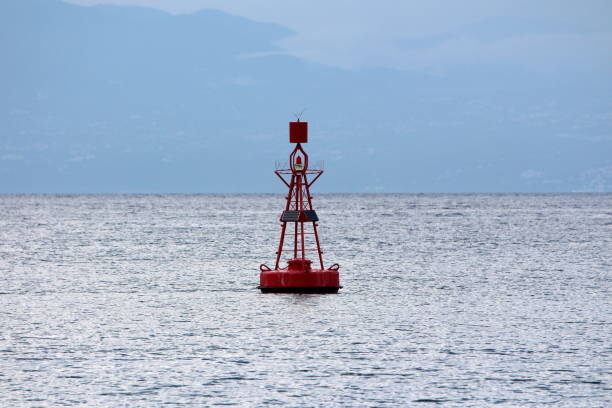 istock Red navigational buoy with light on top and small solar panels for charging surrounded with restless sea 1087531408