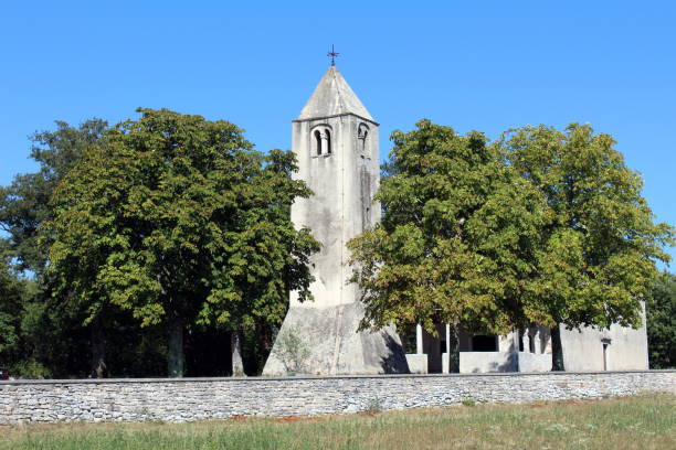 istock Stone church tower behind tall trees 1087531540