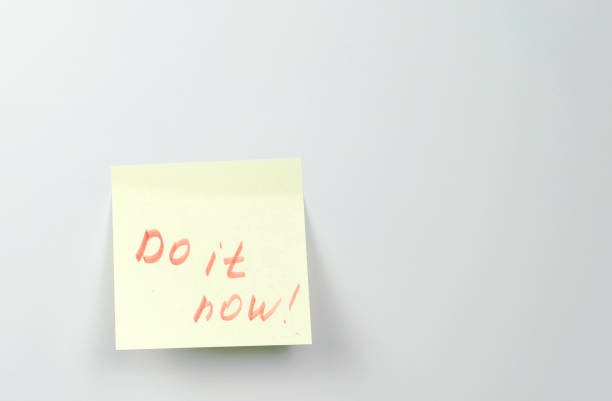 istock Note on yellow sticker paper sheets with motivation words do it now. 1087534834