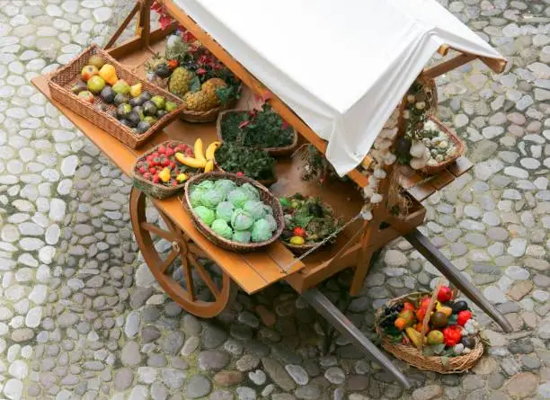 ancient medieval greengrocer's cart with fresh fruit and vegetables for sale on the street