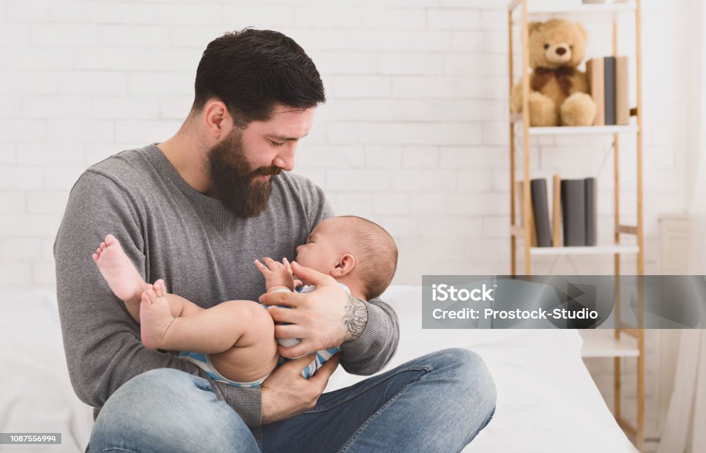 Padre sosteniendo y relajante a bebé recién nacido que llora en sus brazos - Foto de stock de Bebé libre de derechos