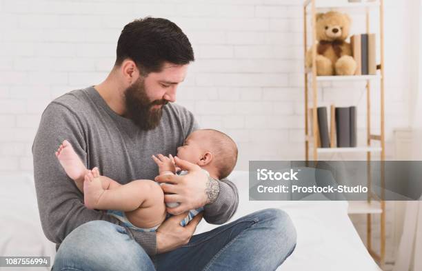Padre Sosteniendo Y Relajante A Bebé Recién Nacido Que Llora En Sus Brazos Foto de stock y más banco de imágenes de Bebé