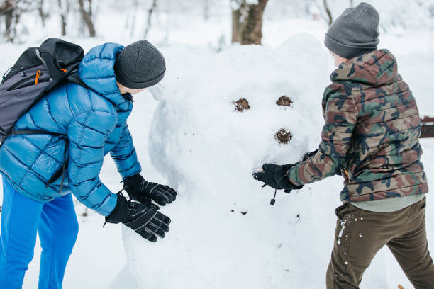 istock Children Making a Snowman Bear 1087557988