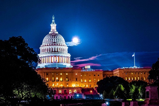 Vista de la Capital de Estados Unidos en Washington DC del edificio por la noche con luna llena y nubes en segundo plano photo