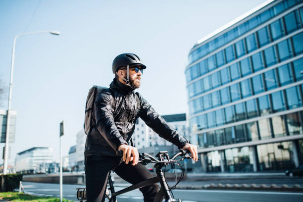 istock Male courier with bicycle delivering packages in city. Copy space. 1087563780