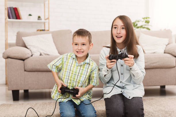 istock Brother and sister playing video games together 1087565450