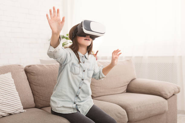 istock Girl in virtual reality headset watching video at home 1087565492