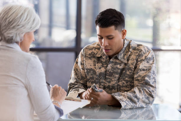istock Male in military uniform looks down at hat while talking to counselor 1087566254