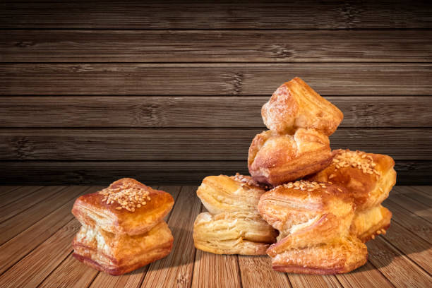 Bunch Of Delicious Freshly Baked Small Square Sesame Puff Pastry Zu-Zu Offered On Rustic Bamboo Place Mat