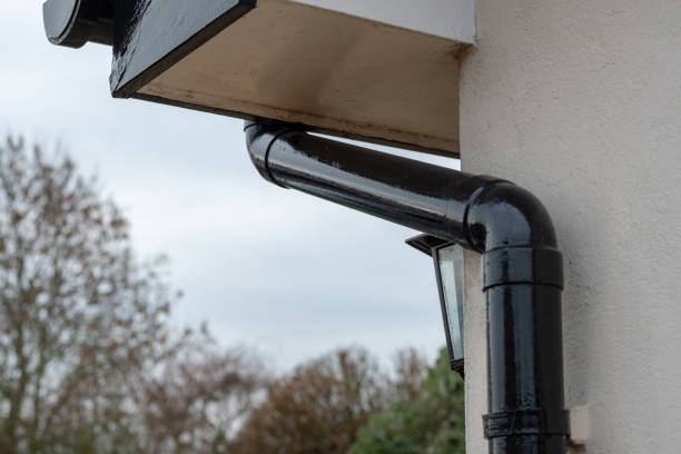 istock Detailed view of a newly painted gutter and down pipe drainage system seen together with part of a security lantern at the porch of a large house during winter. 1087568452