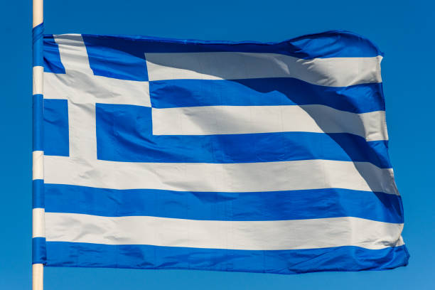 istock Greek flag on pole waving over blue background 1087568980