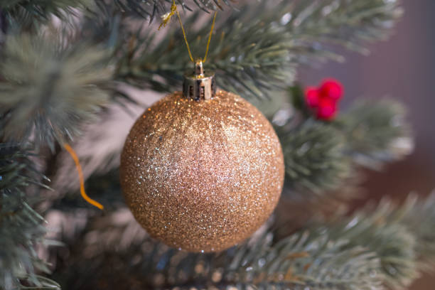 istock Golden Christmas ornaments hanging from christmas tree 1087570104