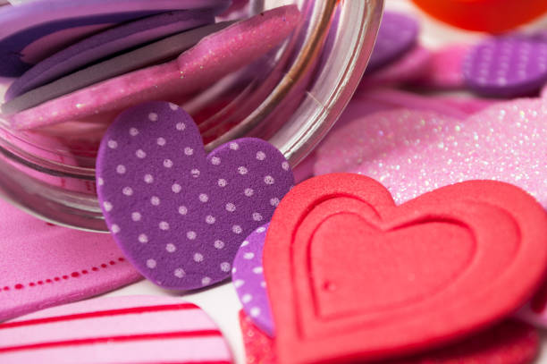 istock pink and red hearts falling  from glass container on white background - valentine's day concept 1087572060