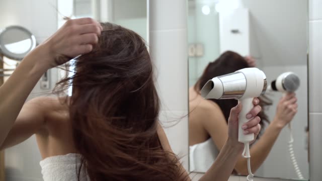 Hair Care. Woman Drying Long Hair With Hairdryer At Bathroom
