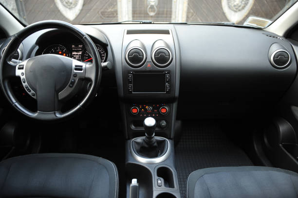 Modern luxury prestige car interior, dashboard, steering wheel. Black perforated leather interior.