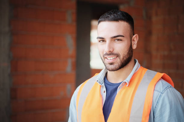 istock Young Construction Worker Smiling At Camera In New Building 1087582788