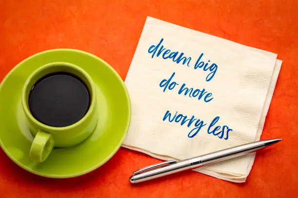 dream big, do more, worry less - inspirational handwriting on a napkin with a cup of coffee