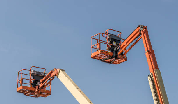 istock Two Cherry Picker machines against a blue sky 1087587096