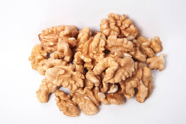 istock Whole unpeeled and broken walnuts on white background. 1087593522