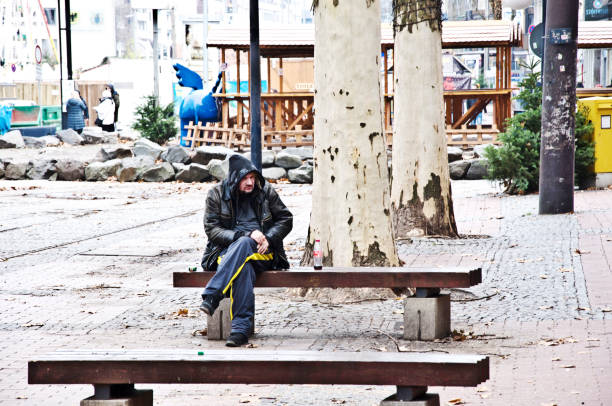 Homeless man sitting on a park bench in Dortmund - German