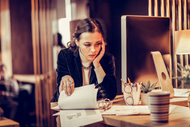 istock Tired young female working consciously at her project 1087598422