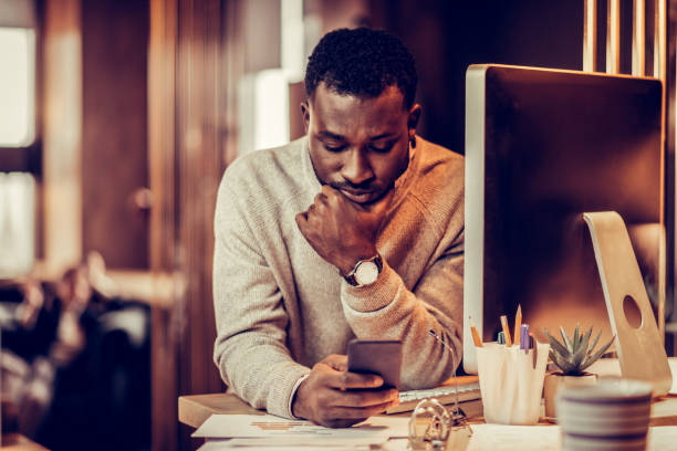 istock Serious dark-skinned man staring at his smartphone 1087599452