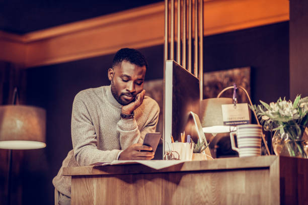 istock Bored international man reading message on telephone 1087599460