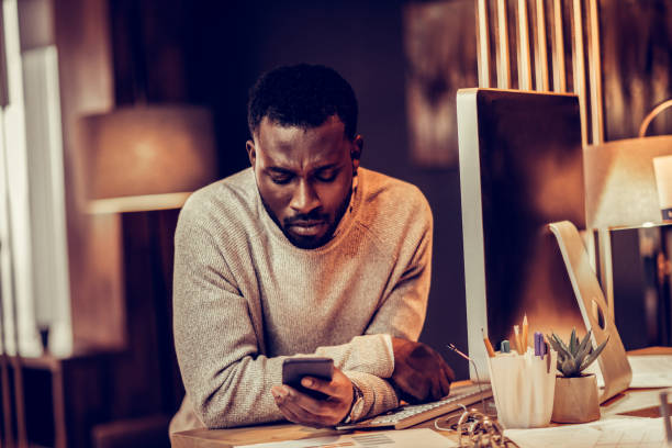 istock Concentrated international bearded man reading income message 1087599470